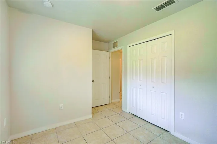 Unfurnished bedroom featuring a closet and light tile patterned floors