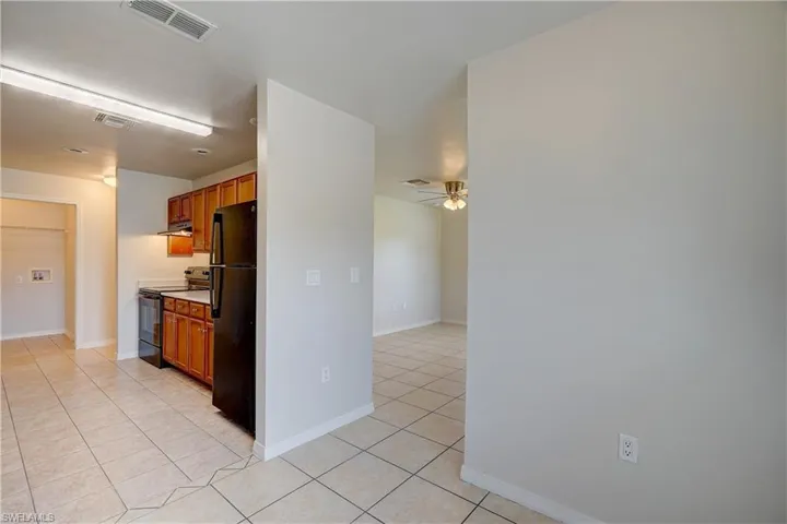 Kitchen featuring black appliances, light tile patterned flooring, and ceiling fan