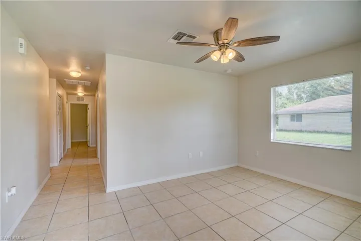 Tiled empty room featuring ceiling fan
