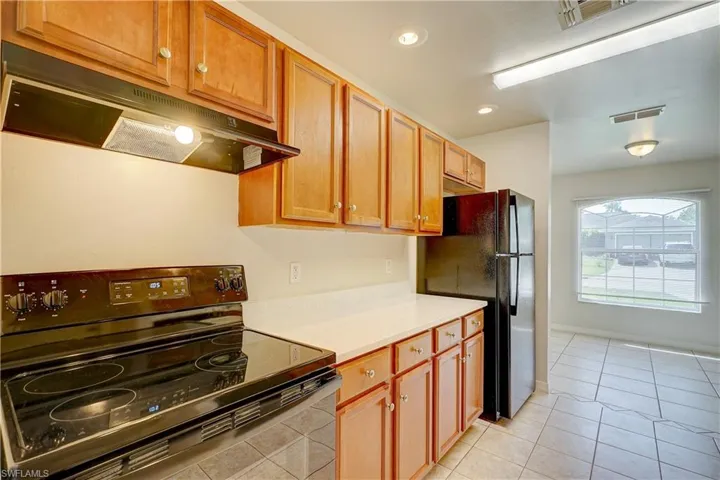 Kitchen featuring black appliances and light tile patterned flooring