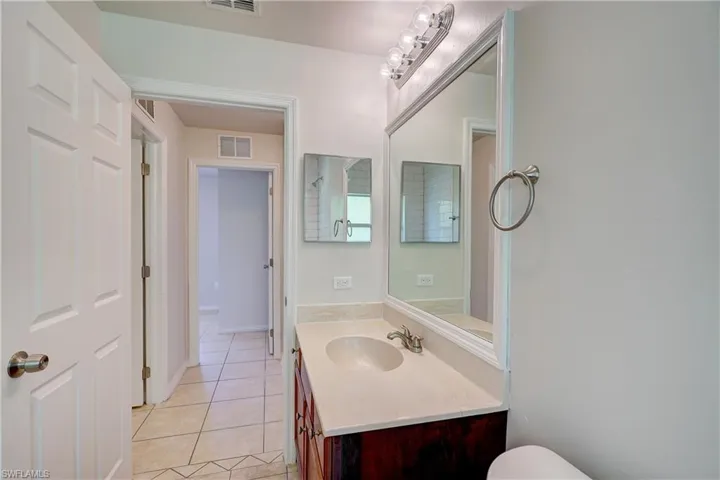 Bathroom featuring tile patterned flooring, vanity, and toilet
