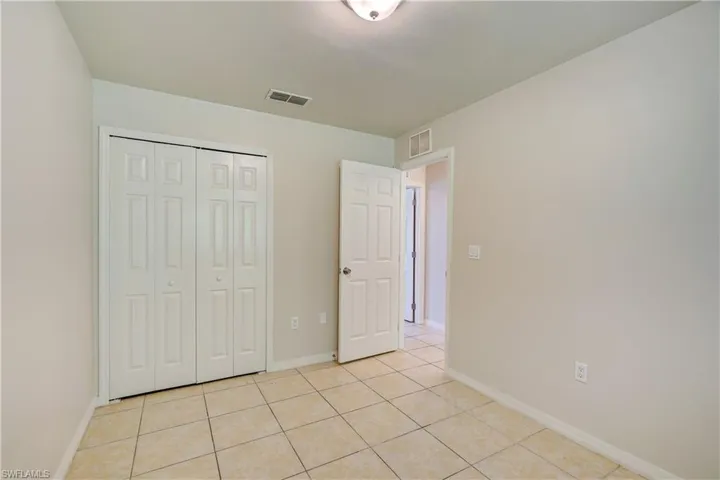Unfurnished bedroom with a closet and light tile patterned floors