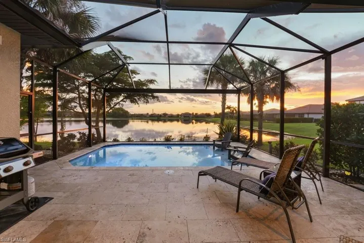 Screened-in lanai featuring a private swimming pool, direct lake access, and a spacious paver patio