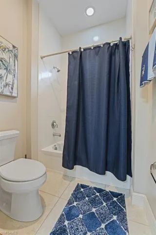 Recessed lighting, tile flooring, built-in bathtub, and toilet