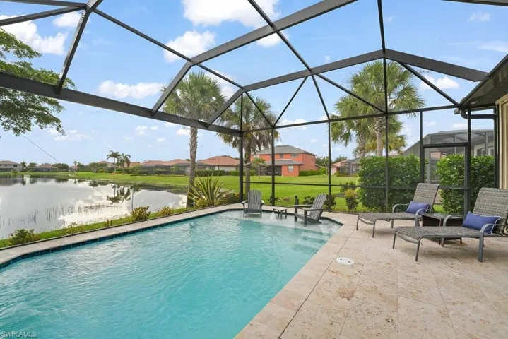 Screened outdoor living space featuring an in-ground pool, a tan paver deck, and extensive water frontage