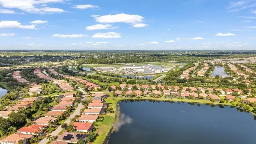 Residential community featuring multiple lakes, abundant mature trees, and a distant commercial building