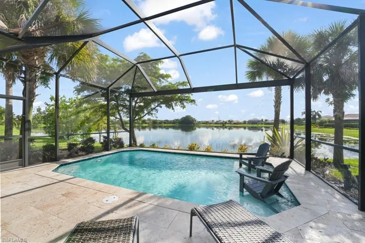 Screened-in outdoor living space featuring a swimming pool, integrated spa, and expansive paver patio