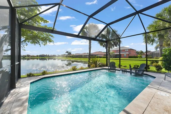 Screened-in outdoor pool featuring a lakefront setting and surrounding patio