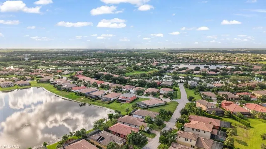 Residential community featuring diverse home styles, mature landscaping, and multiple water features
