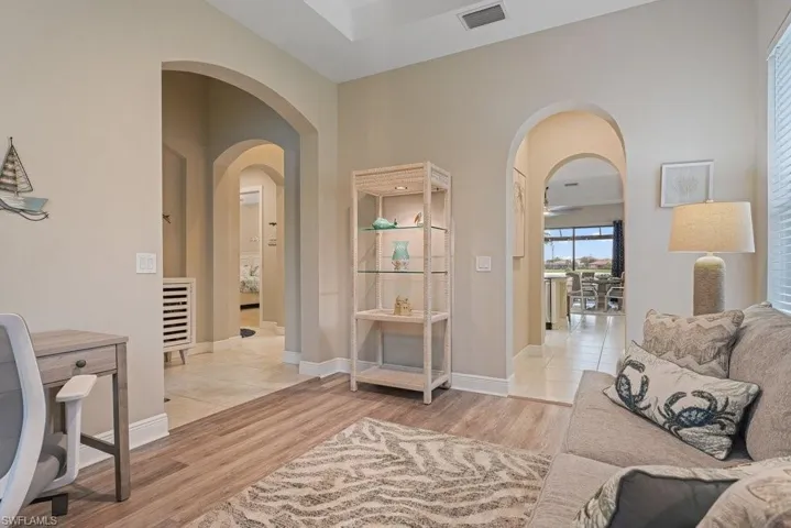 Archways with trim detailing, wood-finish flooring, and recessed lighting