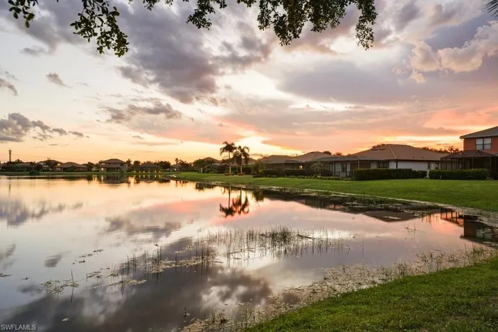 Lakeside property with expansive green lawn, mature landscaping, and waterfront access