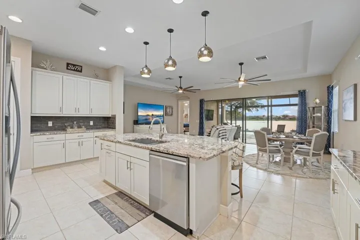 Kitchen featuring white cabinetry, granite countertops, stainless steel appliances, and a tile backsplash