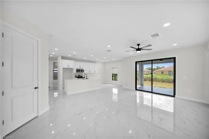 Unfurnished living room featuring sink and ceiling fan