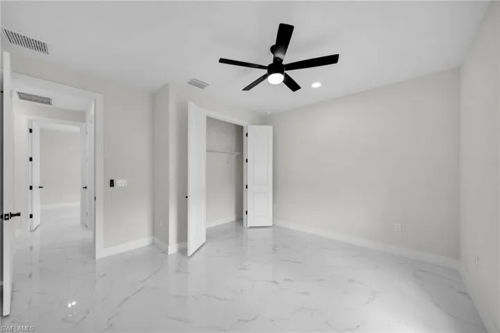 Unfurnished bedroom with ceiling fan and a closet