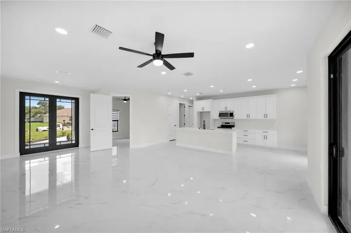 Unfurnished living room featuring ceiling fan and sink