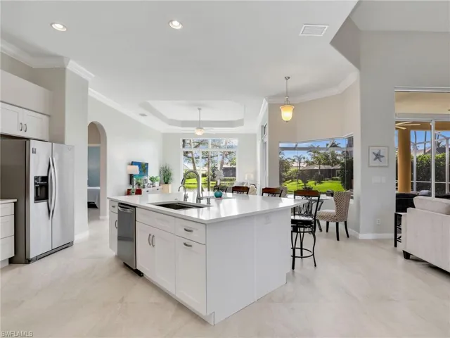 Kitchen featuring appliances with stainless steel finishes, arched walkways, a ceiling fan, white cabinets, and crown molding