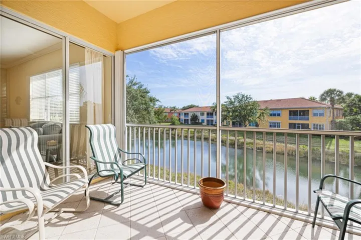 Sunroom with a water view and crown molding