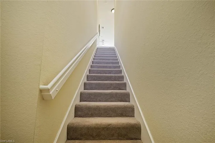 Stairs featuring a textured wall