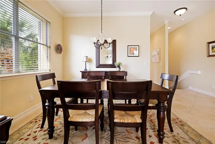 Dining room with a chandelier, crown molding, and baseboards