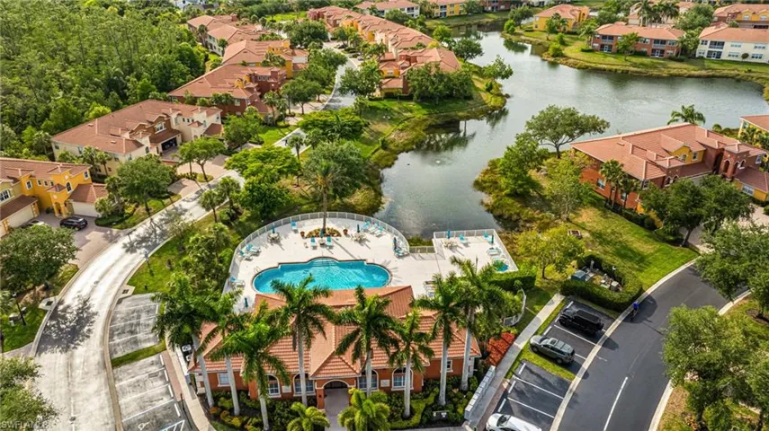 Aerial perspective of suburban area with a nearby body of water and a pool