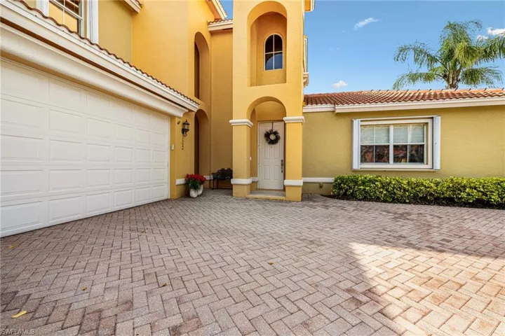 View of front of home with a tile roof, a garage, decorative driveway, and stucco siding