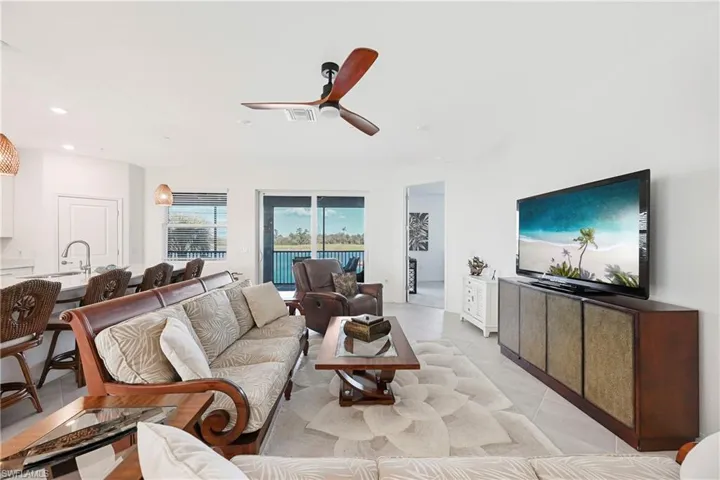 Living room with ceiling fan, recessed lighting, and light tile patterned flooring