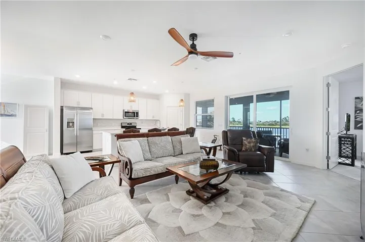 Living area with ceiling fan, recessed lighting, and light tile patterned flooring