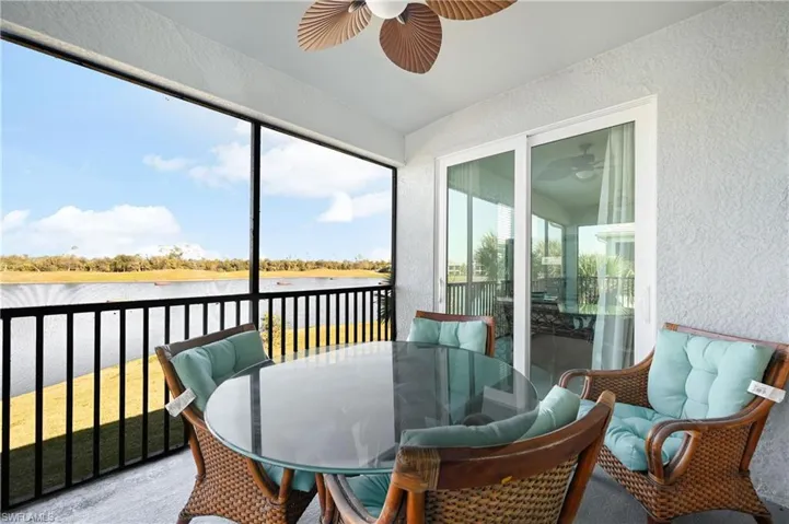 Sunroom / solarium with outdoor dining area, ceiling fan, and a water view
