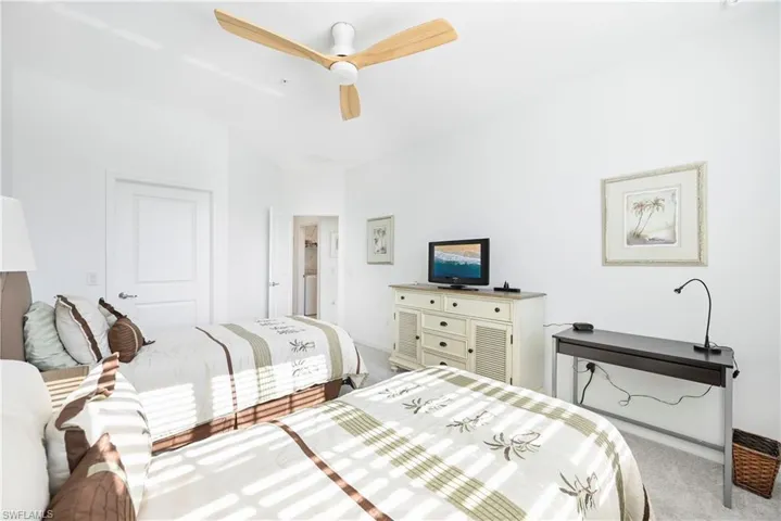 Bedroom featuring light carpet, ceiling fan, and a closet