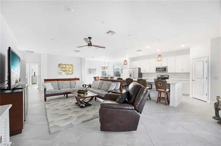 Living area featuring ceiling fan, light tile patterned floors, and recessed lighting