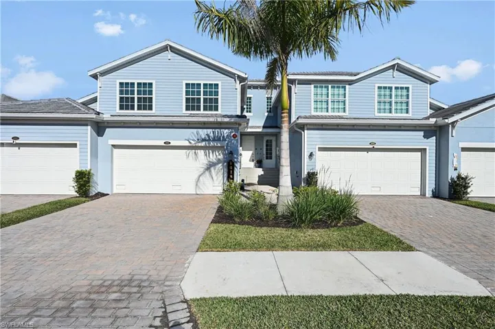 Traditional-style home with decorative driveway and a garage