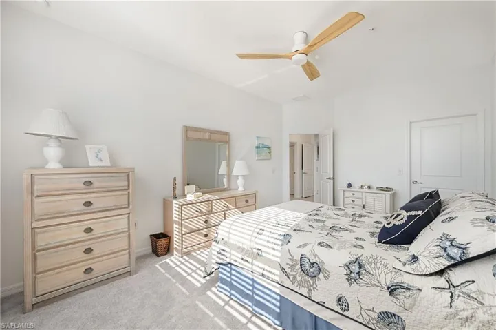 Bedroom with ceiling fan and light carpet