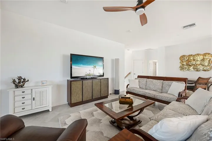 Living room featuring a ceiling fan and baseboards