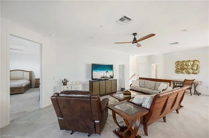 Living area with a ceiling fan and light tile patterned floors