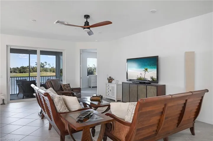 Living room featuring a ceiling fan and light tile patterned floors