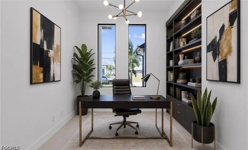 Dedicated office space featuring built-in shelving with integrated lighting, two tall windows, and a modern chandelier