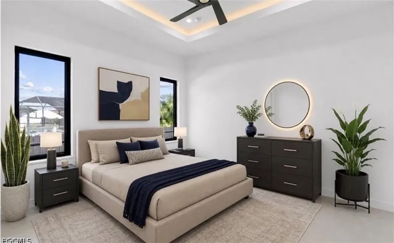 Bright bedroom featuring high ceilings with tray detailing and accent lighting