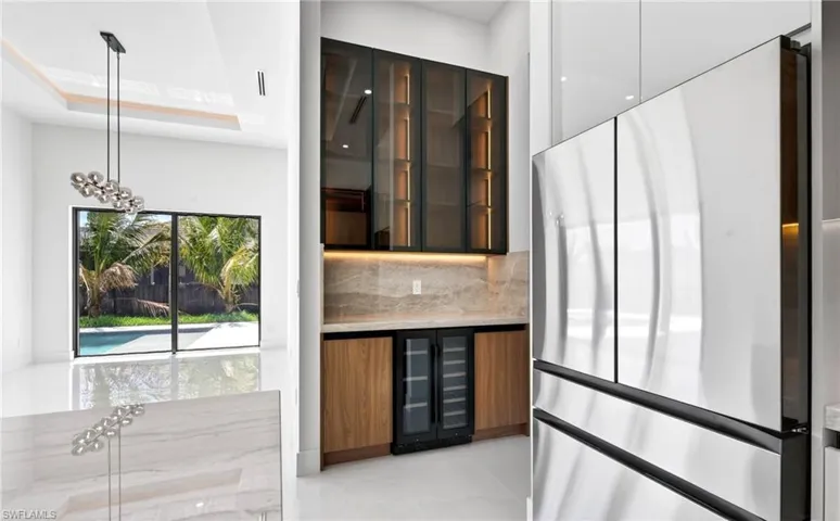 This modern interior features a sleek stainless steel refrigerator and a built-in beverage cooler