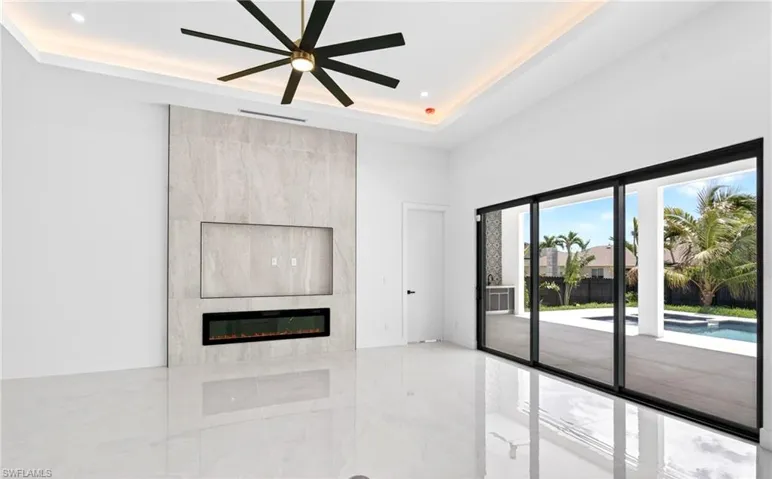 Living area with high ceilings, recessed lighting, and a modern ceiling fan