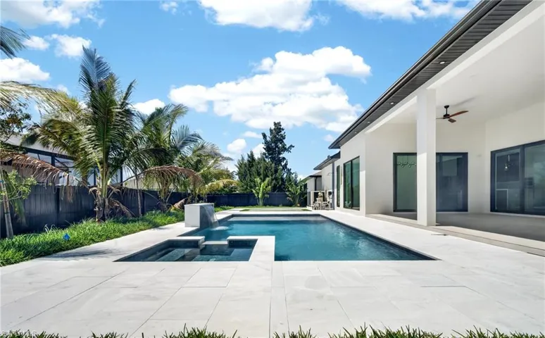 The property features an expansive outdoor living area with a swimming pool, integrated spa, and a spacious tiled patio