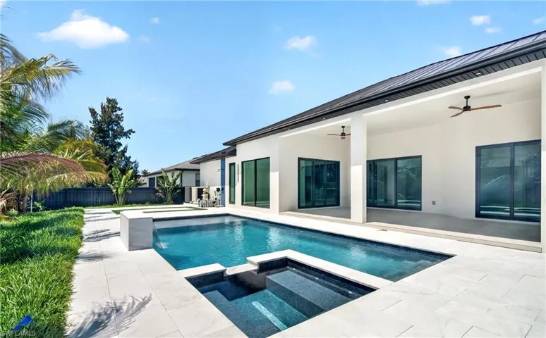 The property features an expansive patio with a swimming pool and an integrated spa