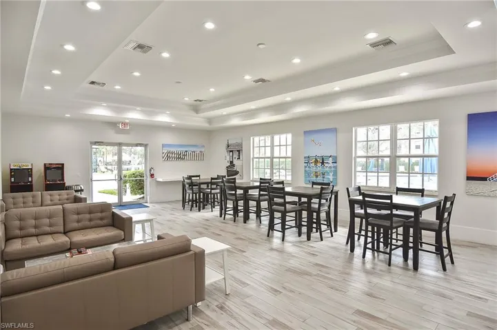 Living room with plenty of natural light, a raised ceiling, and light wood-type flooring