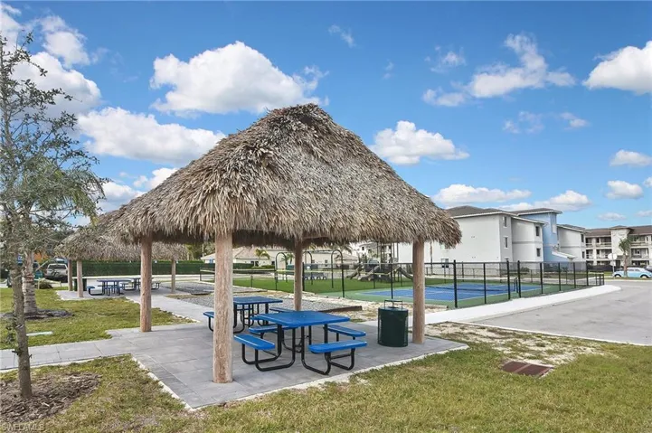 View of community with a gazebo, a lawn, and tennis court