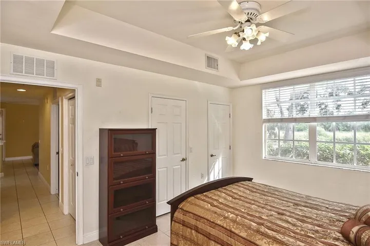 Tiled bedroom featuring ceiling fan