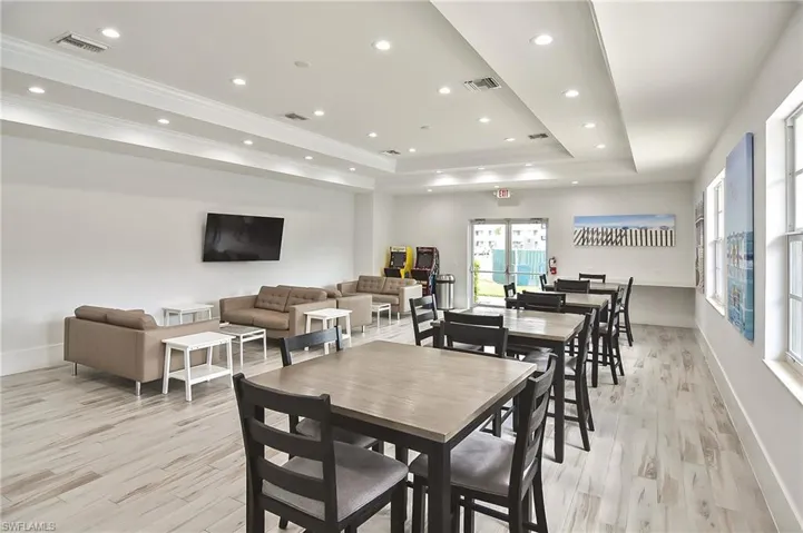 Dining area featuring light hardwood / wood-style floors, a raised ceiling, and crown molding