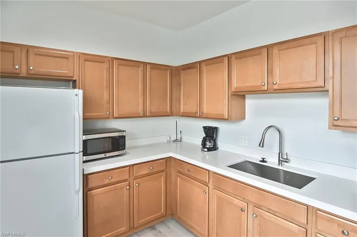 Kitchen featuring sink, light hardwood / wood-style flooring, and white refrigerator