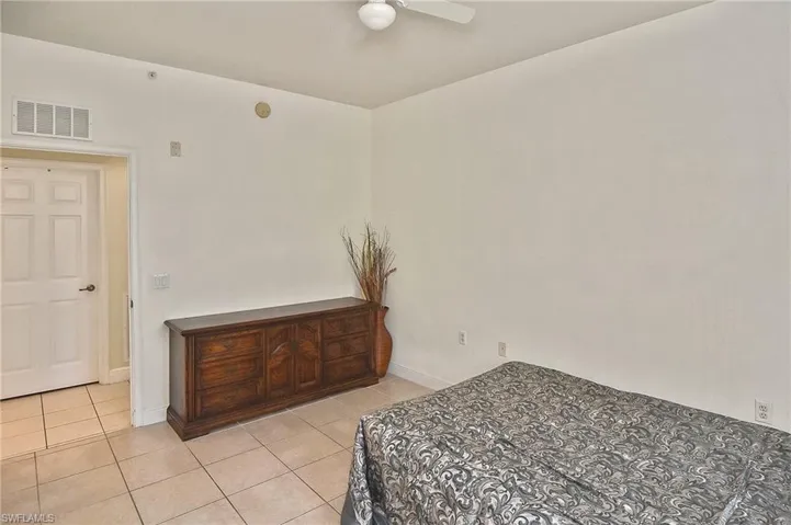 Bedroom with ceiling fan and light tile patterned flooring