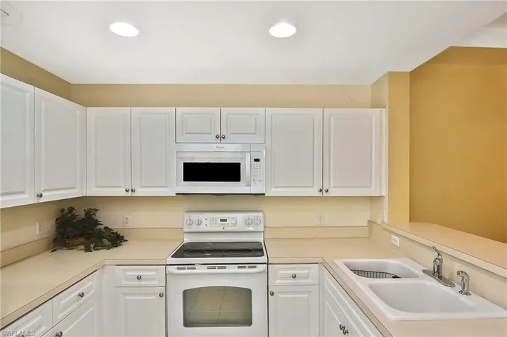 Kitchen featuring white cabinets and white appliances