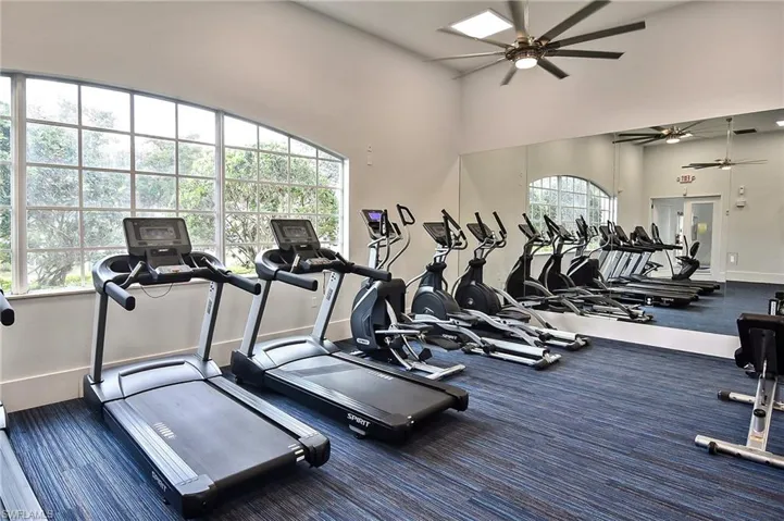 Gym with plenty of natural light, ceiling fan, and a high ceiling