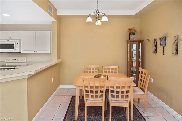 Tiled dining area featuring a chandelier
